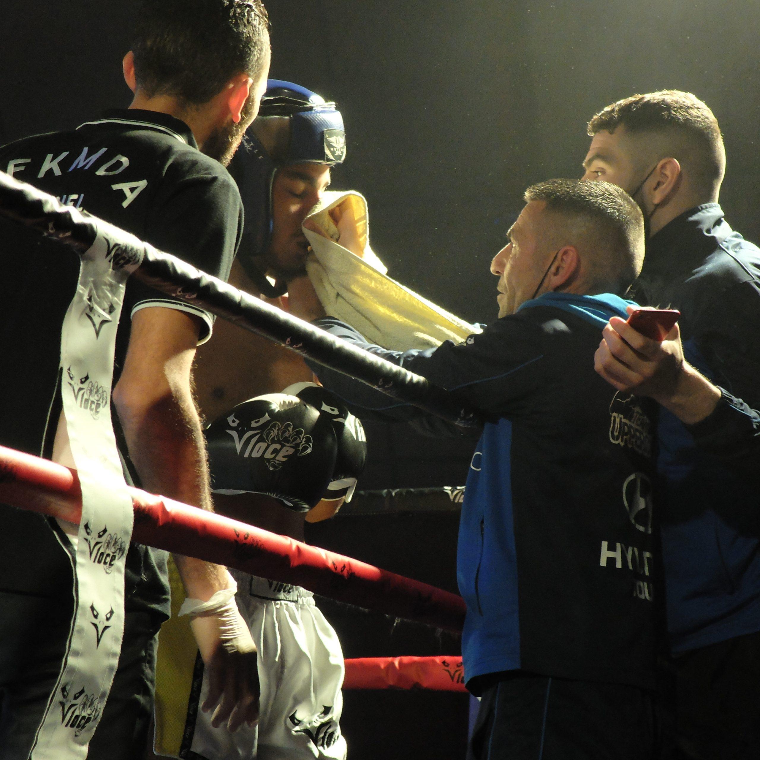 photo de boxeur et ses entraineurs sur le ring