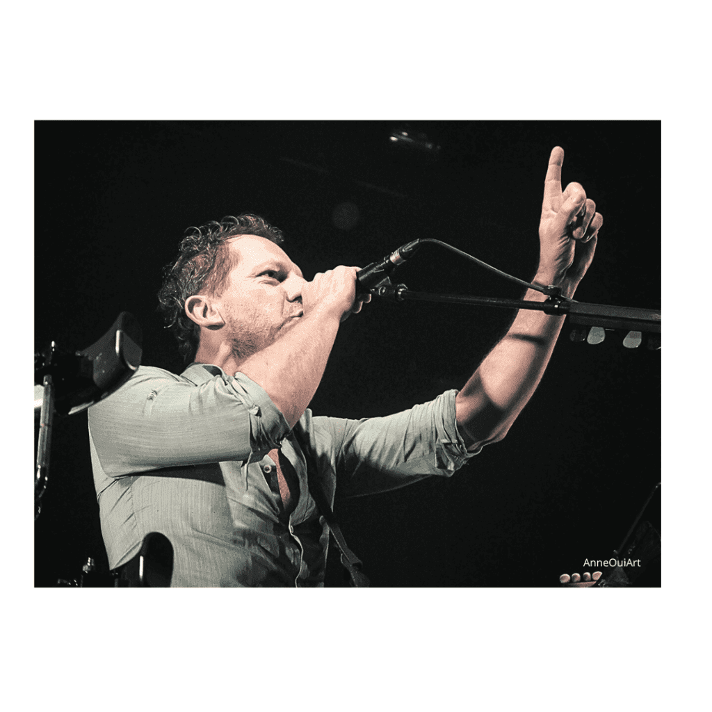 Tom Barman du groupe dEUS band, photographé en concert dans l'objectif de © Anne Cueff